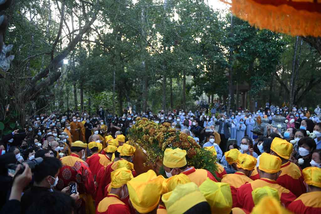 Jenazahnya dibawa ke tempat kremasi terbuka pada Sabtu pagi, diikuti oleh puluhan ribu orang, termasuk biksu Buddha dengan jubah kuning dan coklat dan pengikut berpakaian abu-abu.