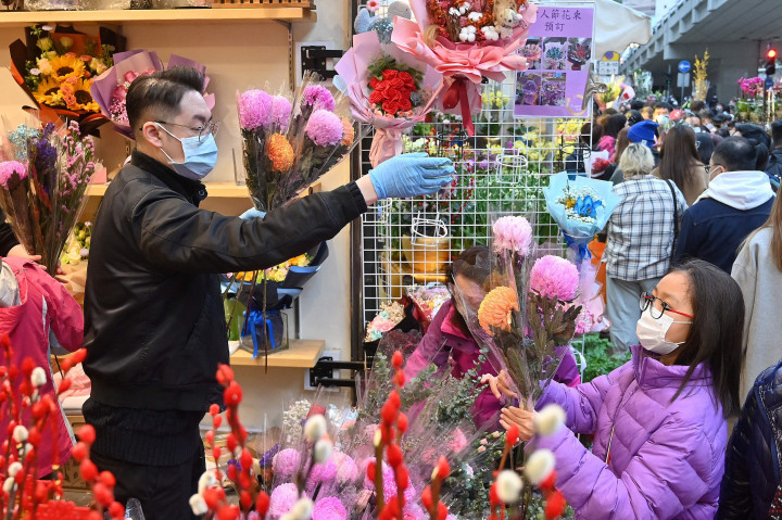 Orang-orang membeli dekorasi Tahun Baru Imlek di pasar untuk merayakan Tahun Baru Imlek.