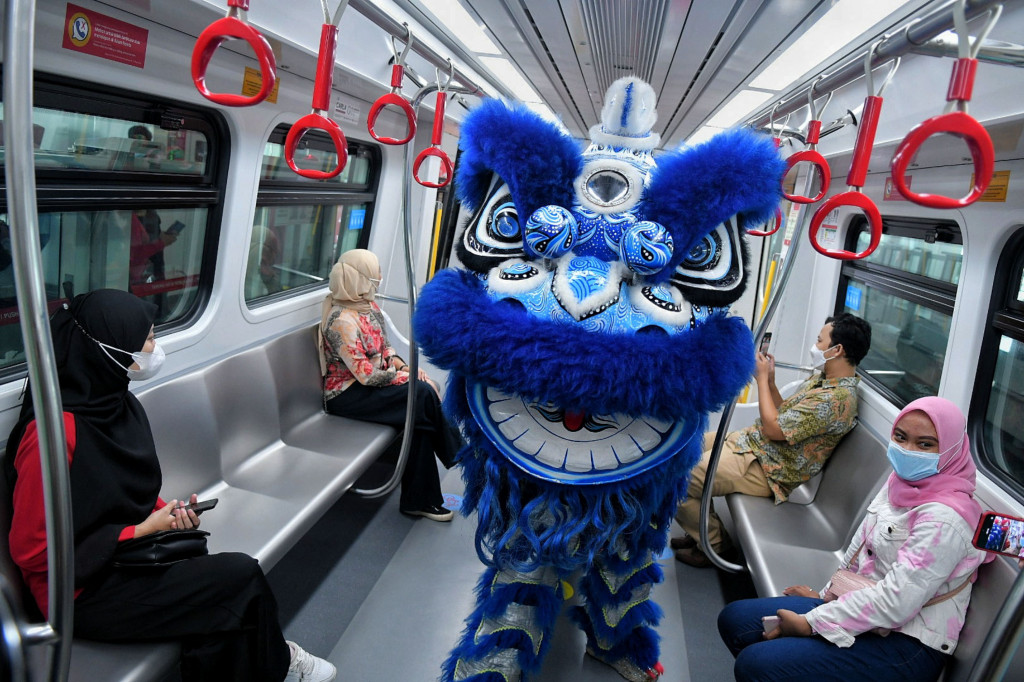 Barongsai beratraksi di kereta LRT rute Velodrome-Boulevard Utara, Jakarta, Selasa, 1 Februari 2022. 