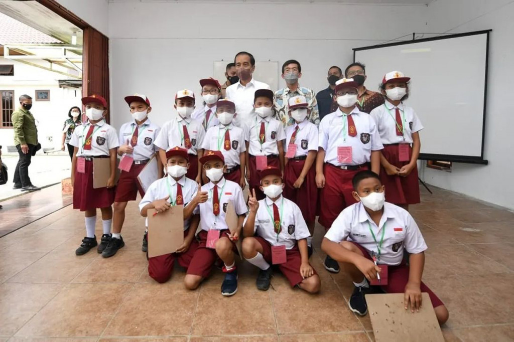 Presiden Joko Widodo berfoto bersama sejumlah anak yang tengah belajar matematika di kawasan Kantor Bupati Humbang Hasundutan, Sumatera Utara, Kamis, 3 Februari 2022.