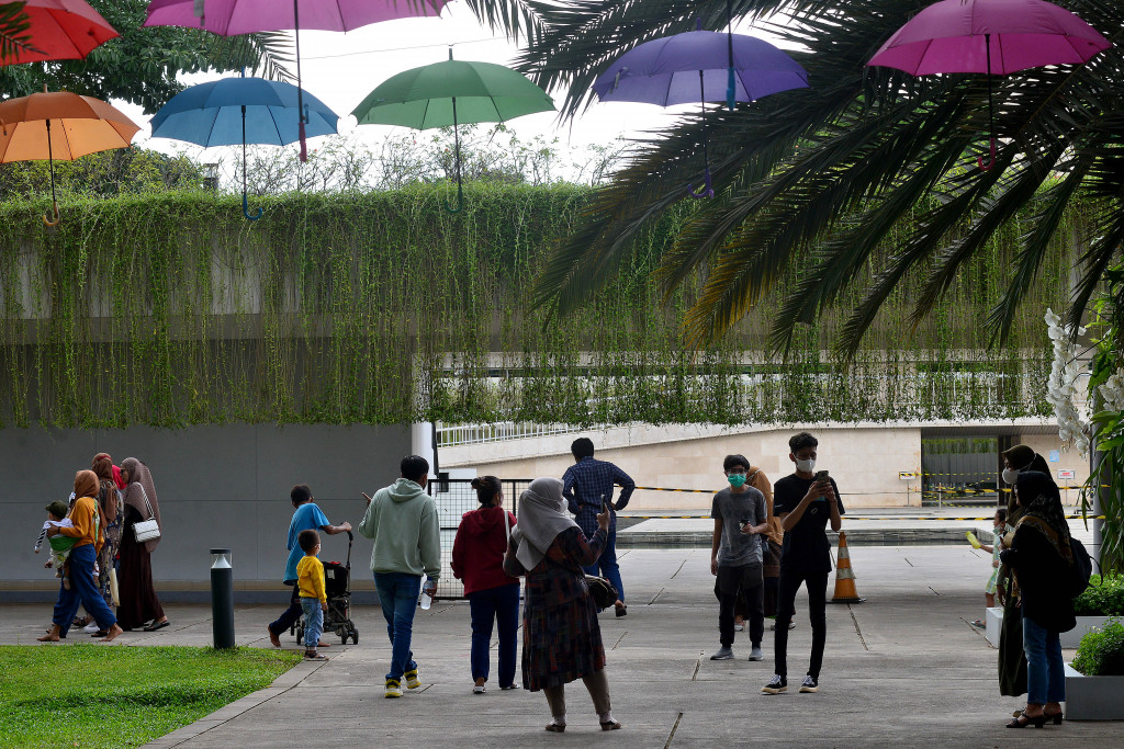 Warga masyarakat mengunjungi taman kota Lapangan Banteng di Jakarta, Minggu, 6 Februari 2022. 