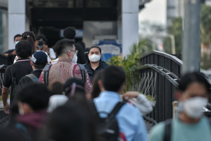 Sejumlah pekerja berjalan menuju halte Transjakarta Tosari, di Jakarta, Senin, 7 Februari 2022.