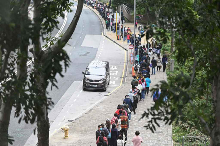 Puluhan warga antre untuk menjalani tes PCR secara massal di distrik Tung Chung, Hong Kong, Kamis, 10 Februari 2022.