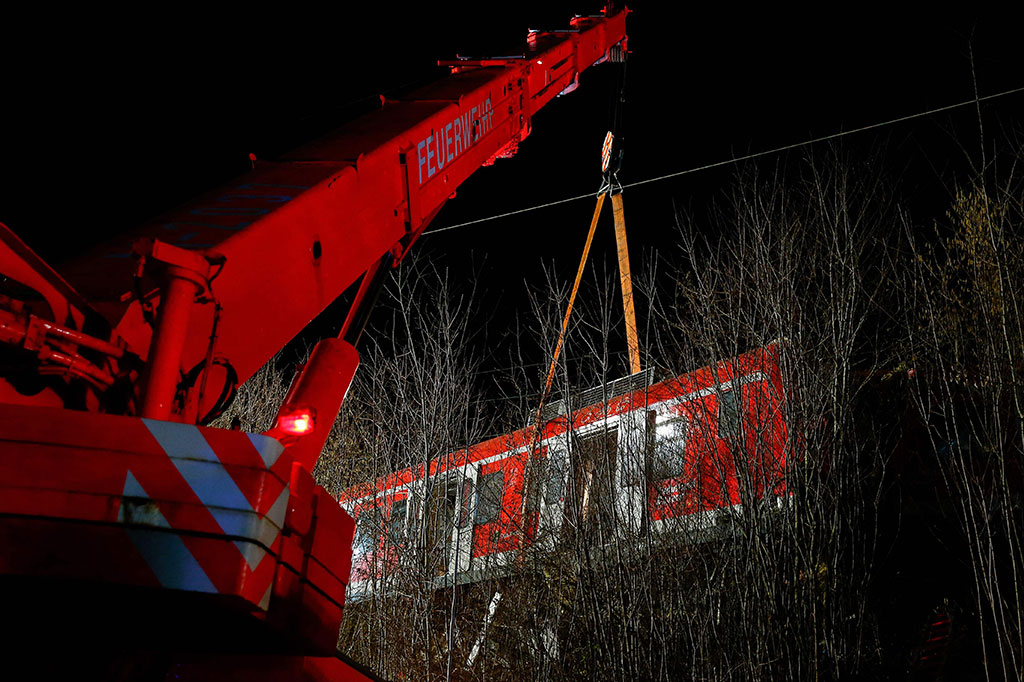 Anggota layanan darurat bekerja di lokasi kecelakaan kereta api komuter S-bahn, di mana satu orang meninggal dan 14 lainnya terluka dalam tabrakan antara dua kereta pinggiran kota Schaeftlarn di distrik Munich, Jerman selatan pada Senin, 14 Februari 2022.