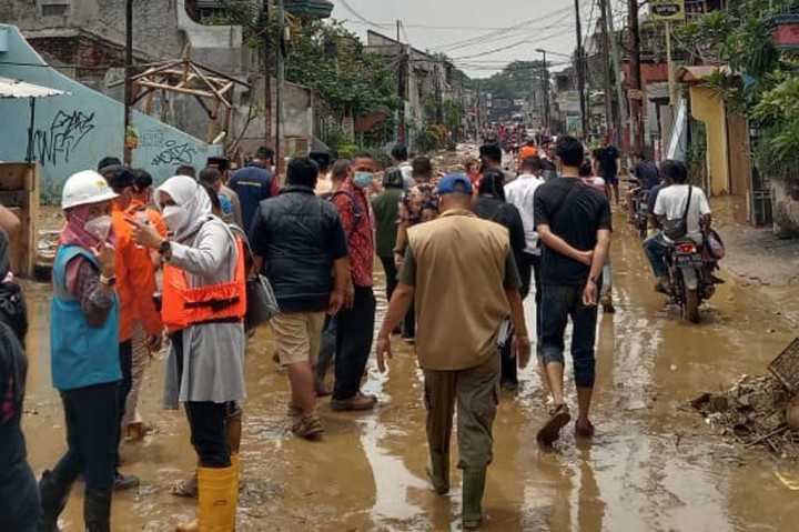 Warga melintasi ruas jalan pascabanjir melanda sejumlah wilayah Kota Bekasi, Jawa Barat, Kamis, 17 Februari 2022.