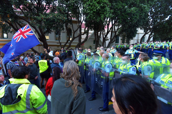 Polisi memegang perisai anti huru hara ketika para demonstran menentang mandat dan pembatasan vaksin Covid-19 berkumpul di luar halaman Parlemen Selandia Baru di Wellington, Selandia Baru, pada 22 Februari 2022.