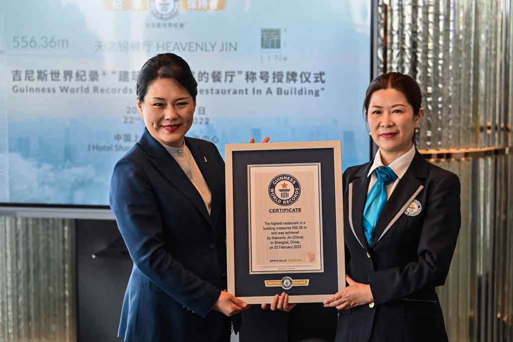 Jenny Zhang (kiri), Genera Manager J Hotel Shanghai Tower, menerima sertifikat Guinnes World Records untuk restoran tertinggi di gedung yang diberikan kepada restoran Heavenly Jin, yang terletak sekitar 556,36 meter di atas tanah, di lantai 120 Menara Shanghai, di Shanghai pada Rabu, 22 Februari 2022.