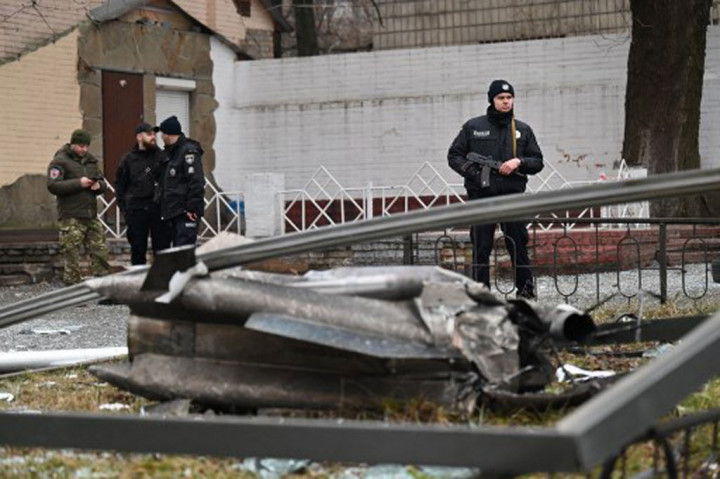 Polisi berjaga-jaga di dekat sisa-sisa peluru yang berserakan di jalanan di Kyiv pada 24 Februari 2022.