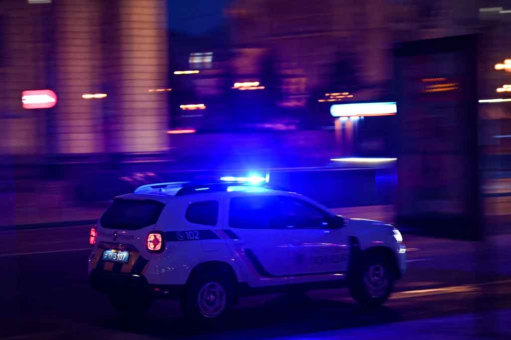 Sebuah mobil polisi melaju di Khreshchyatyk Avenue utama Kyiv mendesak semua orang untuk tetap tenang dan berlindung.