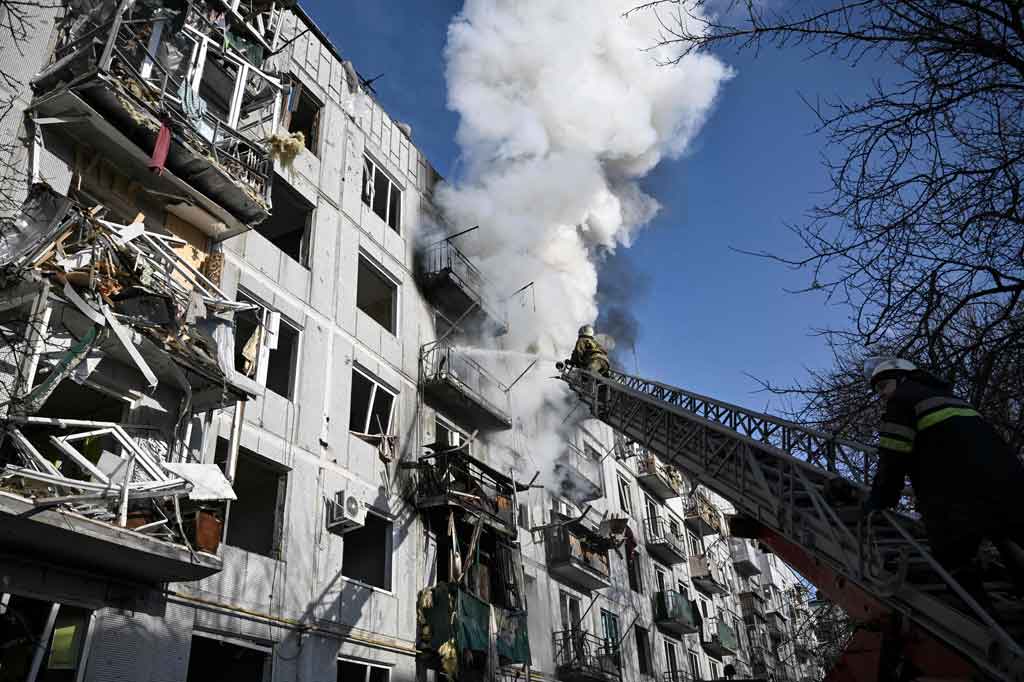 Sementara petugas pemadam kebakaran berusaha memadamkan api dari sebuah rumah yang terbakar setelah terjadi serangan.
