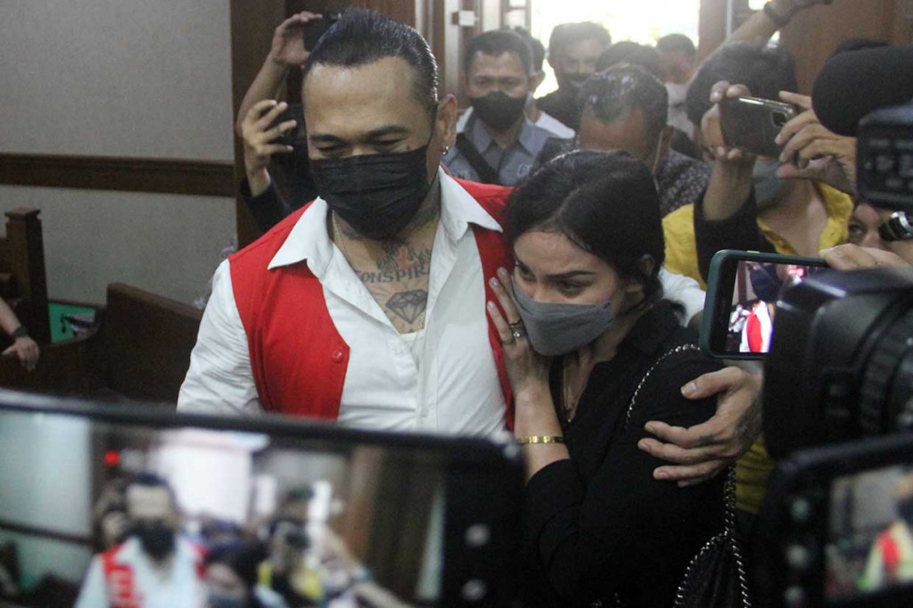 Terdakwa yang juga musisi I Gede Ari Astina atau Jerinx Superman is Dead (SID) bersama istrinya saat akan menjalani sidang lanjutan kasus pengancaman melalui media elektronik pada Adam Deni beragendaka pebacaan putusan majelis Hakim di Pengadilan Negeri (PN) Jakarta Pusat, Jakarta, Kamis, 24 Februari 2022.