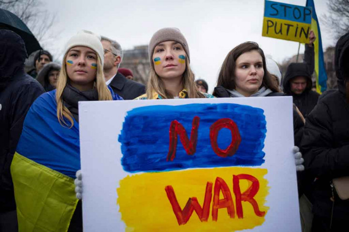 Aktivis memegang plakat ketika mereka berkumpul di Lafayette Square untuk memprotes invasi Rusia ke Ukraina di Washington, DC, pada Kamis, 24 Februari 2022 waktu setempat. AFP PHOTO/Mandel Ngan