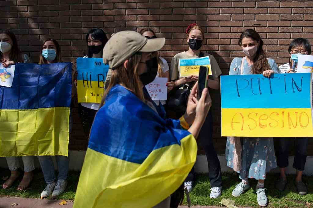 Warga Ukraina memegang poster saat protes mendukung Ukraina di depan Kedutaan Besar Rusia di Santiago, pada 24 Februari 2022. AFP PHOTO/Martin Bernetti