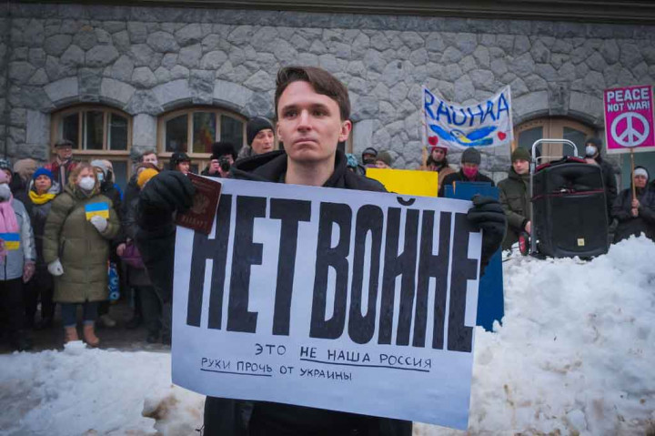 Seorang pria memegang plakat bertuliskan 