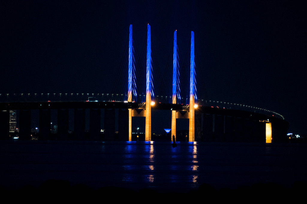Pemandangan menunjukkan tiang di Jembatan Oresund, antara Denmark dan Swedia, menyala kuning dan biru untuk mendukung Ukraina, seperti yang terlihat dari Kopenhagen, Denmark.