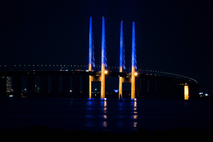 Pemandangan menunjukkan tiang di Jembatan Oresund, antara Denmark dan Swedia, menyala kuning dan biru untuk mendukung Ukraina, seperti yang terlihat dari Kopenhagen, Denmark.