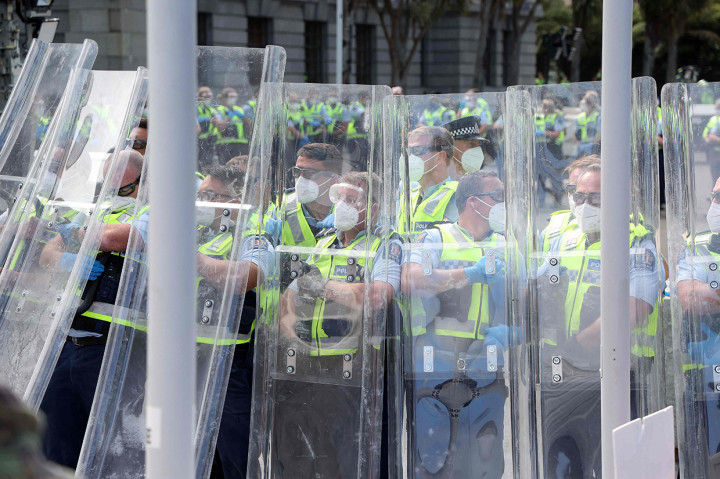 Aparat polisi berjaga selama menghadapi demonstrasi yang menentang pembatasan dan memprotes vaksin Covid-19 di depan Parlemen di Wellington.