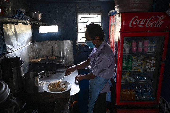 Penjual menyiapkan makanan di tokonya setelah pemadaman listrik di Kolombo, 2 Maret 2022.