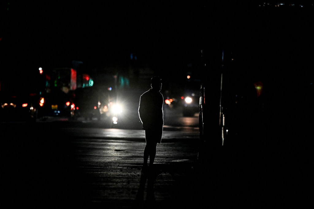 Seorang pria berjalan melintasi jalan saat listrik padam di Kolombo pada 2 Maret 2022.