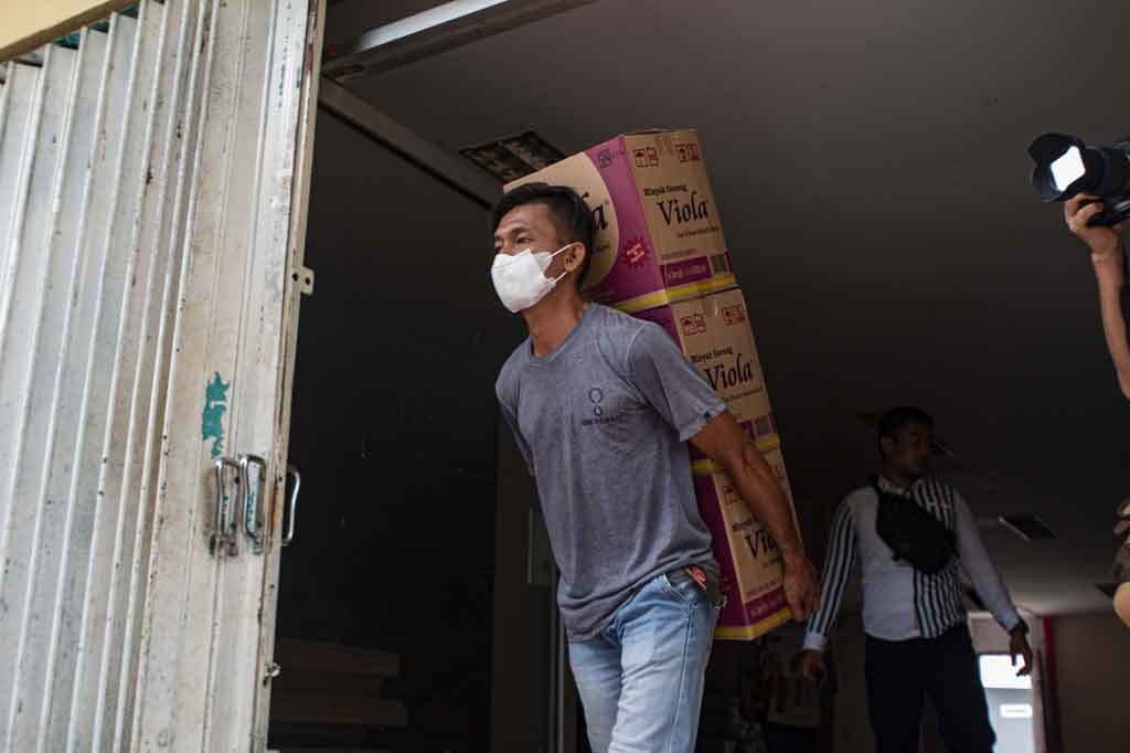 Pekerja mengeluarkan sejumlah kardus berisi minyak goreng kemasan dua liter untuk didistribusikan ke pasar di Palu, Sulawesi Tengah, Jumat, 4 Maret 2022. 