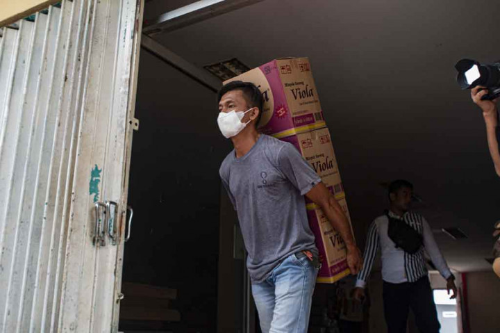 Pekerja mengeluarkan sejumlah kardus berisi minyak goreng kemasan dua liter untuk didistribusikan ke pasar di Palu, Sulawesi Tengah, Jumat, 4 Maret 2022. 