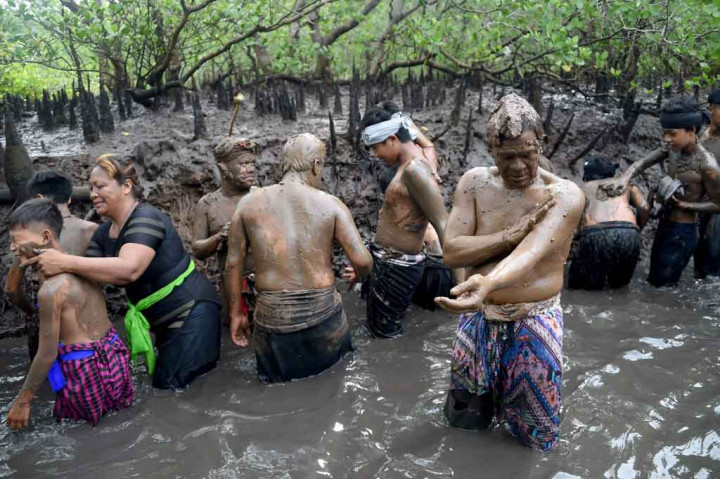 Umat Hindu melaksanakan tradisi Mebuug-Buugan atau mandi lumpur di hutan bakau Desa Kedonganan, Badung, Jumat, 4 Maret 2022.
