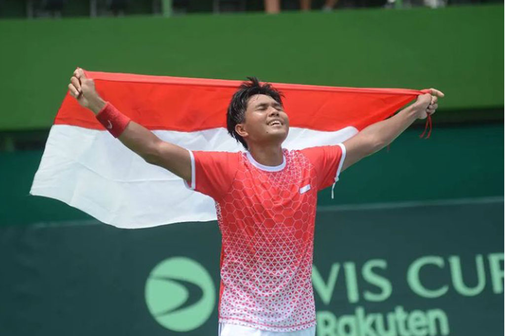 Petenis ganda putra Indonesia Muhammad Rifqi Fitriadi yang berpasangan dengan Christoper Rungkat membawa bendera Merah Putih usai mengalahkan ganda putra Venezuelan dalam pertandingan Playoff Grup II Piala Davis di Stadion Tenis Gelora Bung Karno, Jakarta, Sabtu, 5 Maret 2022.