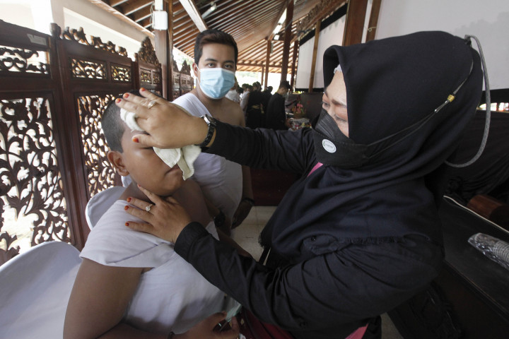 Orangtua peserta membasuh keringat anaknya saat mengikuti ritual yang disebut Ruwat Sukerta di Pendopo Kecamatan Banyumas, Jawa Tengah, Minggu, 6 Maret 2022.