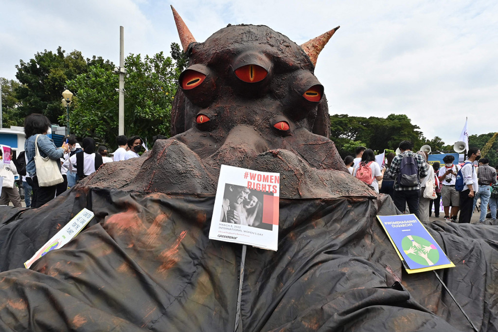 Aktivis Greenpeace membawa replika gurita raksasa bertanduk sebagai simbol oligarki.  
