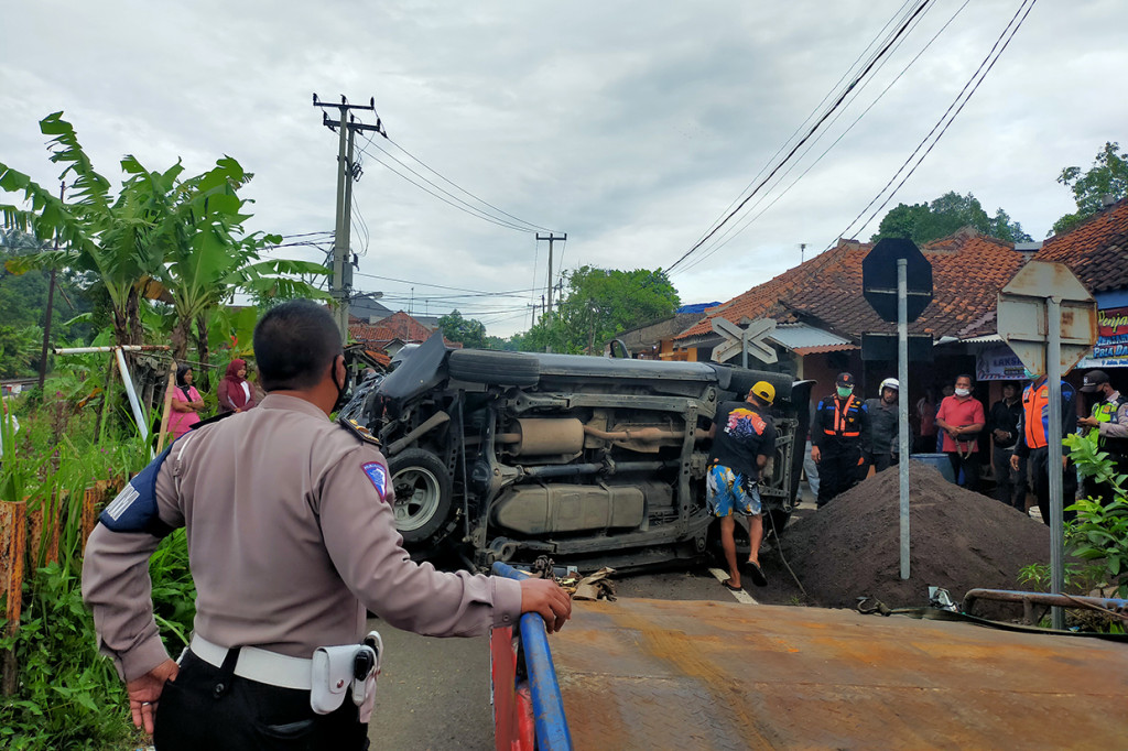 Petugas melakukan evakuasi mobil plat merah setelah tertabrak kereta api barang di perlintasan tanpa palang pintu di Manonjaya, Kamis, 10 Maret 2022.