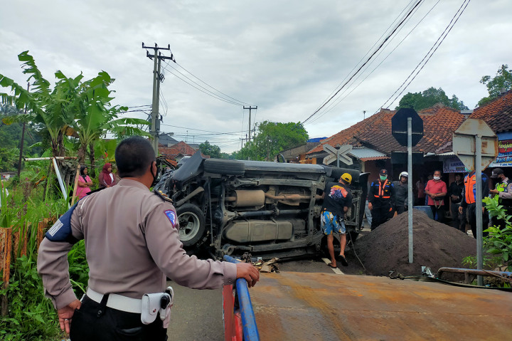 Petugas melakukan evakuasi mobil plat merah setelah tertabrak kereta api barang di perlintasan tanpa palang pintu di Manonjaya, Kamis, 10 Maret 2022.