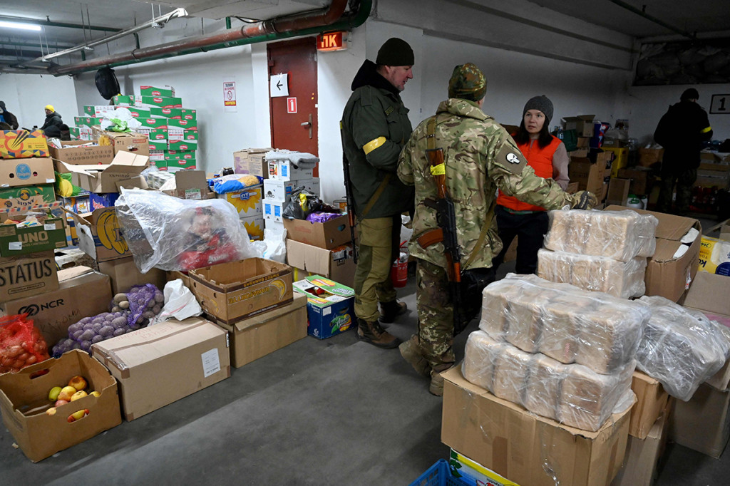 Prajurut Pasukan Pertahanan Teritorial Ukraina, cadangan militer Angkaran Bersenjata Ukraina, menerima makanan di gudang di garasi bawah tanah yang telah diubah menjadi pangkalan pelatihan dan logistik di Kiev, Jumat, 11 Maret 2022.
