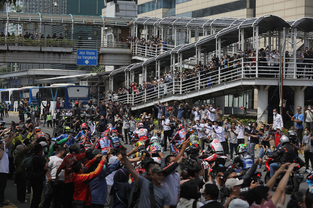 Warga antusias menyambut pembalap MotoGP yang mengikuti parade di kawasan Jalan M.H.Thamrin, Jakarta, Rabu, 16 Maret 2022.