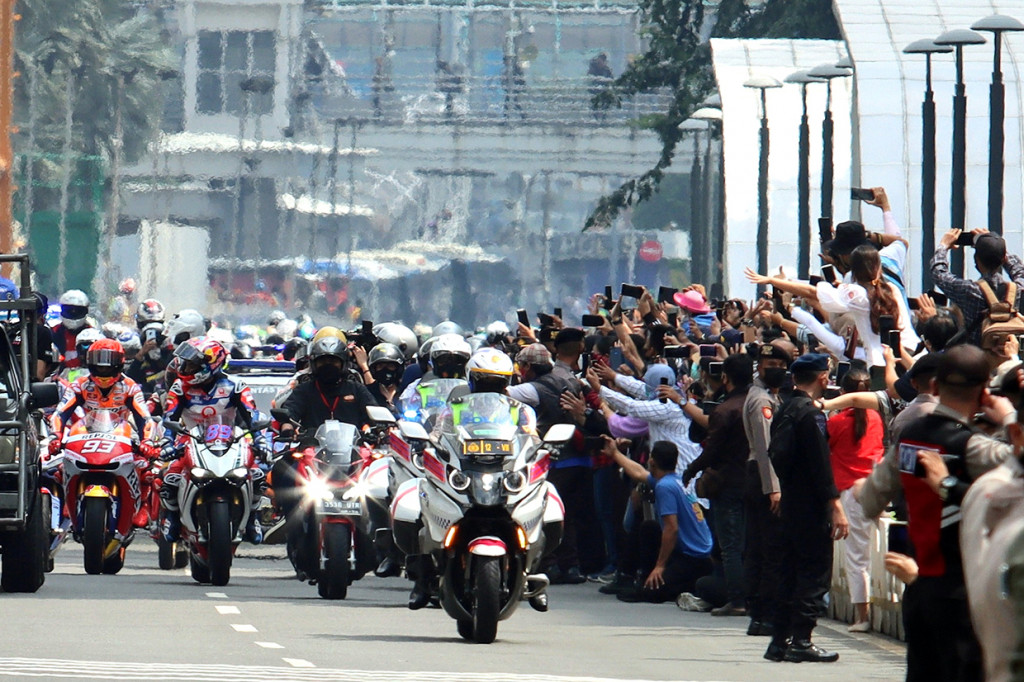Warga antusias menyambut pembalap MotoGP yang mengikuti parade di kawasan Jalan M.H.Thamrin, Jakarta, Rabu, 16 Maret 2022.