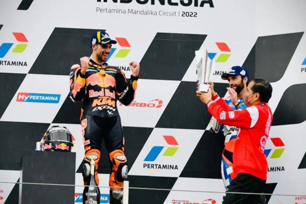 Pembalap tim Red Bull KTM Miguel Oliveira menerima trofi juara Grand Prix Indonesia dari tangan Presiden Joko Widodo.