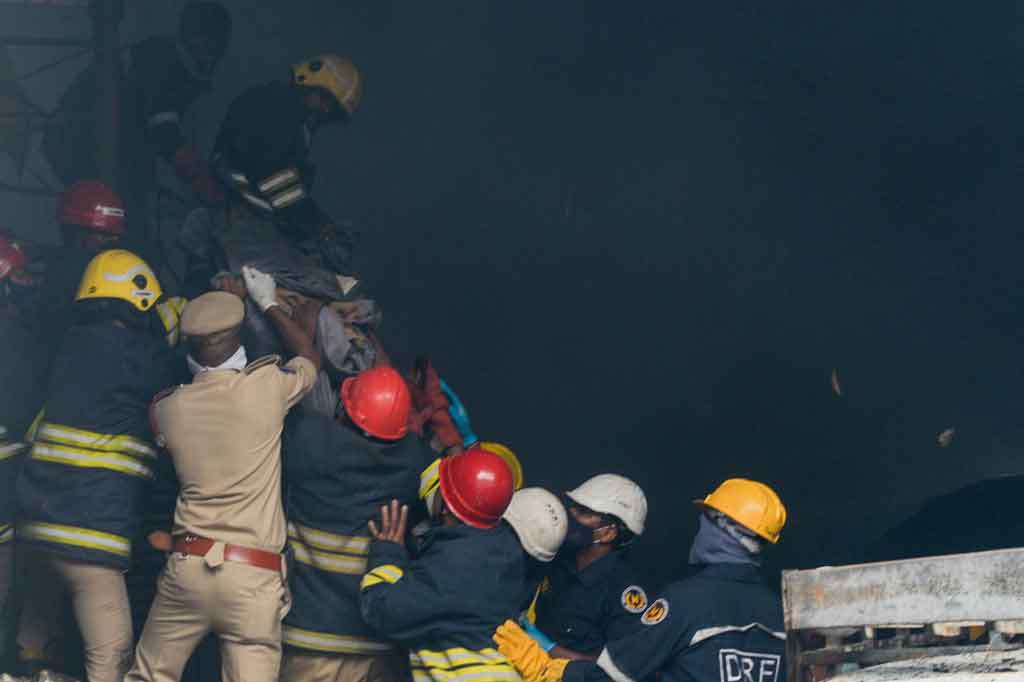 Petugas pemadam kebakaran dan petugas penyelamat mengevakuasi jenazah dari gudang setelah kebakaran terjadi di Secunderabad, India pada Rabu, 23 Maret 2022.