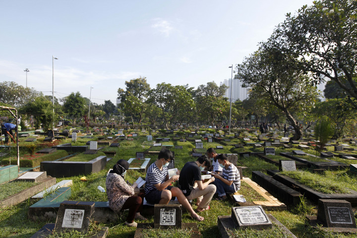 Peziarah memanjatkan doa di makam keluarga dan kerabat di Taman Pemakaman Umum (TPU) Karet Bivak, Jakarta, Minggu, 27 Maret 2022. 