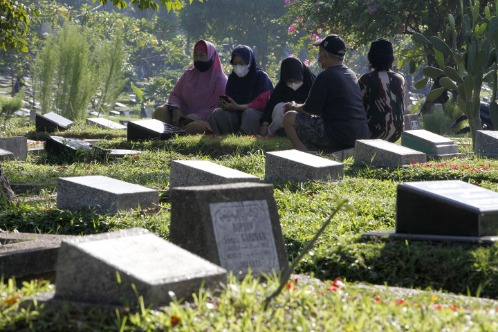 Peziarah memanjatkan doa di makam keluarga dan kerabat di Taman Pemakaman Umum (TPU) Karet Bivak, Jakarta, Minggu, 27 Maret 2022. 