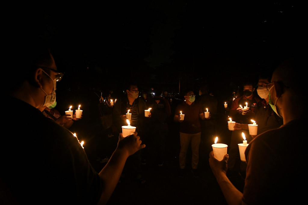 Warga menyalakan lilin saat mengikuti kegiatan pemadaman listrik yang berlangsung selama 90 menit di kawasan perkantoran SCBD, Jakarta Selatan, Sabtu, 26 Maret 2022, malam. 