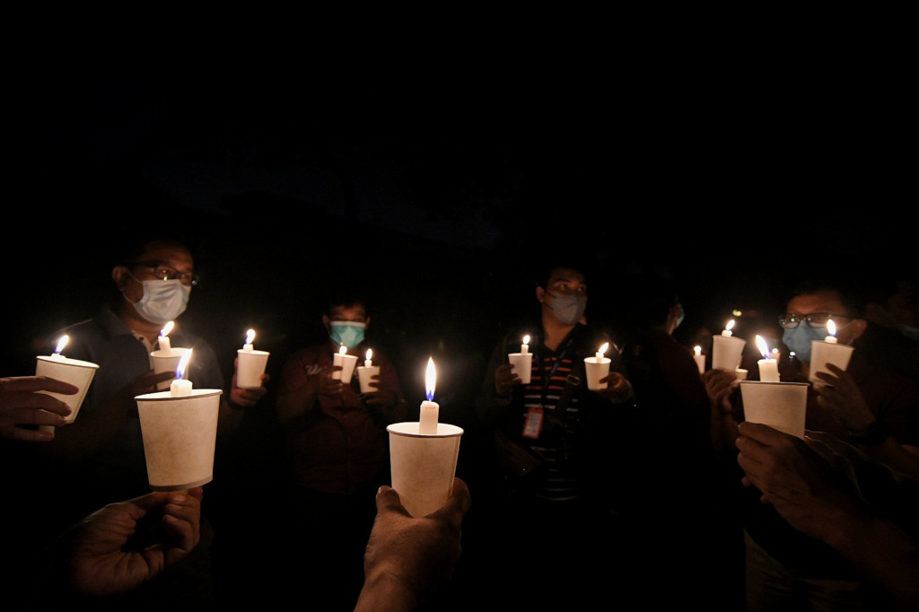 Warga menyalakan lilin saat mengikuti kegiatan pemadaman listrik yang berlangsung selama 90 menit di kawasan perkantoran SCBD, Jakarta Selatan, Sabtu, 26 Maret 2022, malam. 