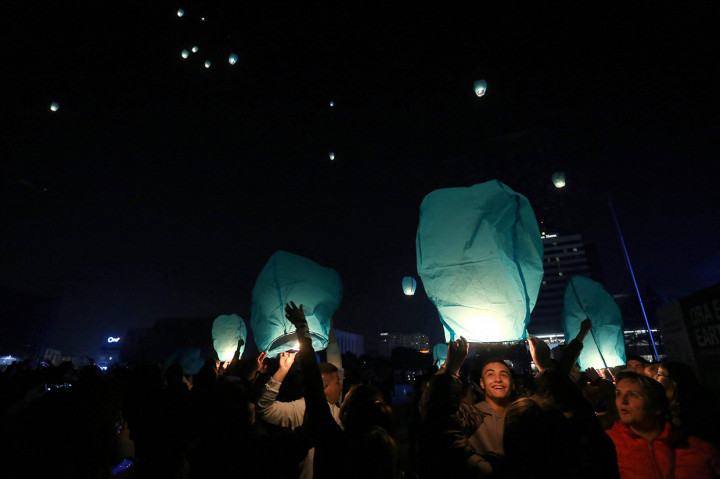 Aktivis menyalakan lentera di alun-alun utama Tirana saat penerangan bangunan utama dimatikan pada kesempatan Earth Hour, pada 26 Maret 2022.