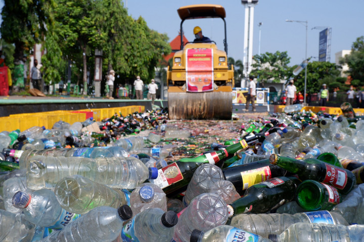 Ribuan botol minuman keras (miras) berbagai jenis dihancurkan dengan digilas menggunakan alat berat, di Alun-Alun Simpang Tujuh Kudus, Rabu, 30 Maret 2022. Miras itu merupakan hasil sitaan dari operasi yang dilakukan Satpol PP Kudus dalam dua tahun terakhir. 
