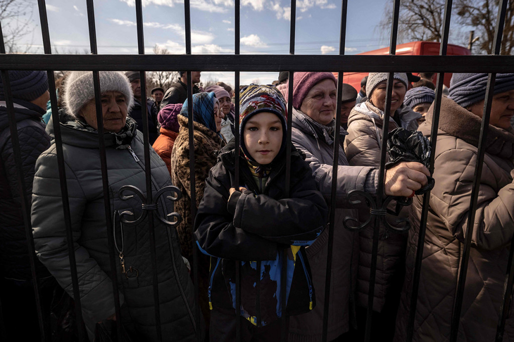 Warga menunggu makanan di luar di sebuah gereja di timur laut kota Trostianets, 29 Maret 2022.