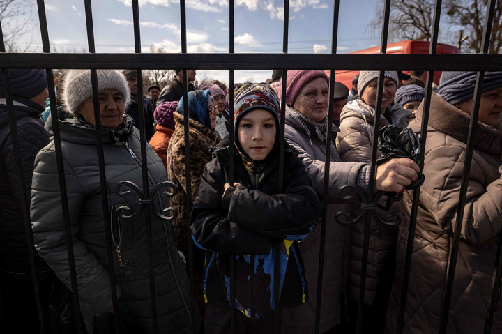 Warga menunggu makanan di luar di sebuah gereja di timur laut kota Trostianets, 29 Maret 2022.