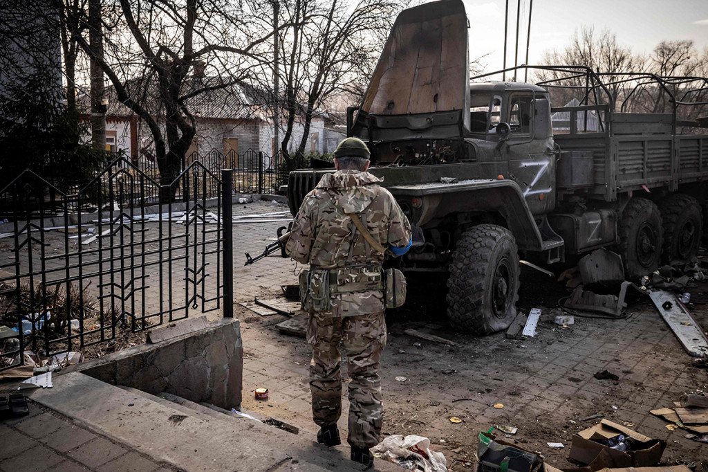 Prajurit Ukraina berdiri di dekat truk tentara Rusia di timur laut kota Trostianets, 29 Maret 2022.
