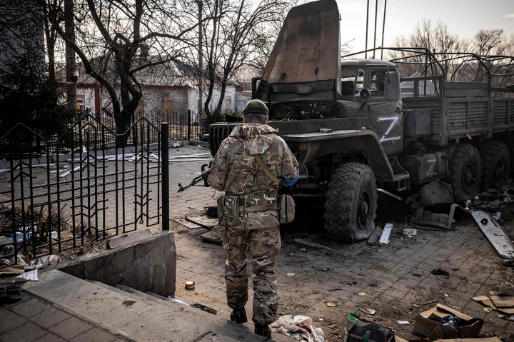 Prajurit Ukraina berdiri di dekat truk tentara Rusia di timur laut kota Trostianets, 29 Maret 2022.
