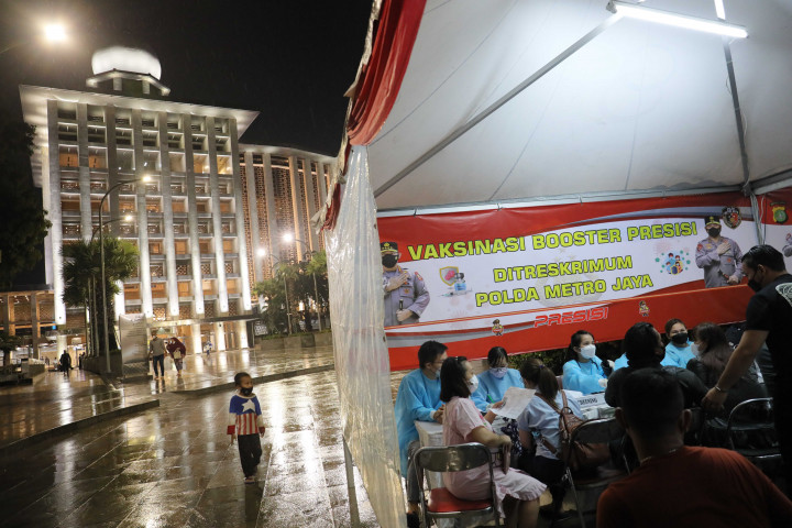 Warga antusias mengikuti vaksinasi Booster di tengah guyuran hujan deras di halaman Masjid Istiqlal, Jakarta, Selasa, 5 April 2022.