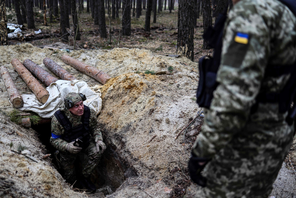 Sejumlah tentara Ukraina mengecek lokasi beberapa hari setelah pasukan Rusia mundur dari daerah tersebut.