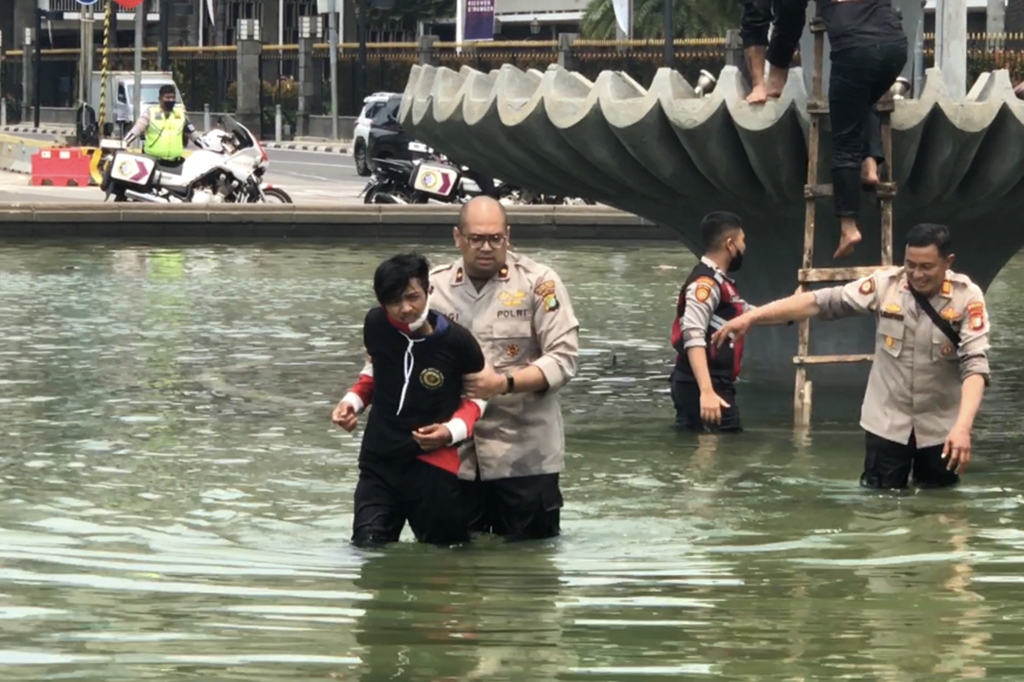 Pantauan Medcom.id, pemuda tersebut menggunakan jaket hitam dan celana panjang hitam. Dia juga memakai masker dan pelindung lengan berwarna merah putih.