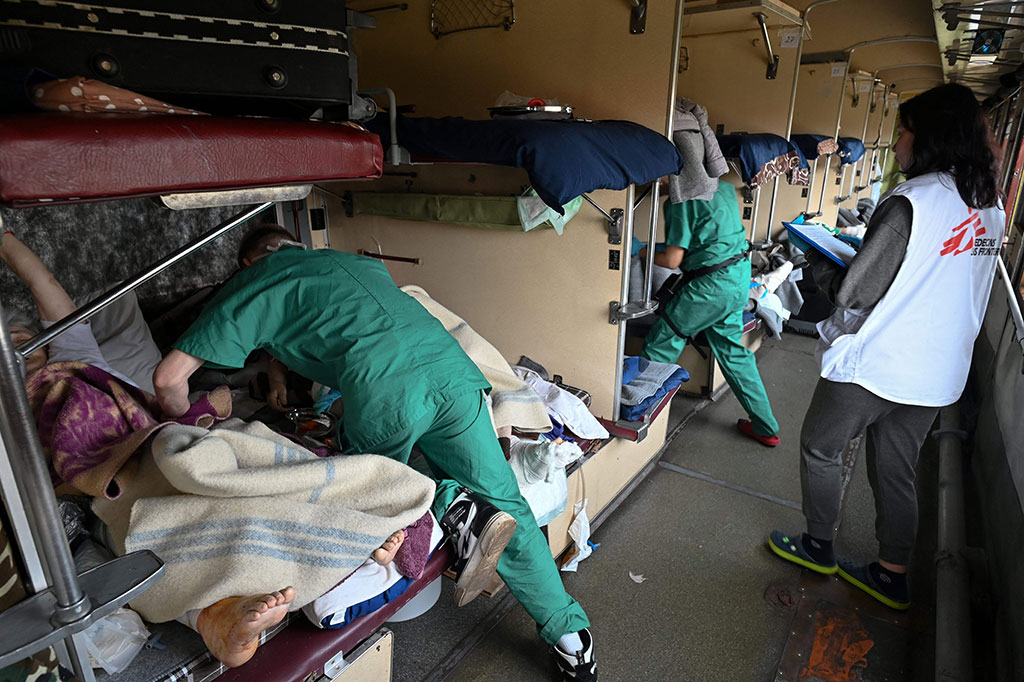 Tim medis Doctors Without Borders (MSF) merawat pasien di kereta rumah sakit dalam perjalanan ke Kota Lviv, Ukraina barat pada Minggu, 10 April 2022. 